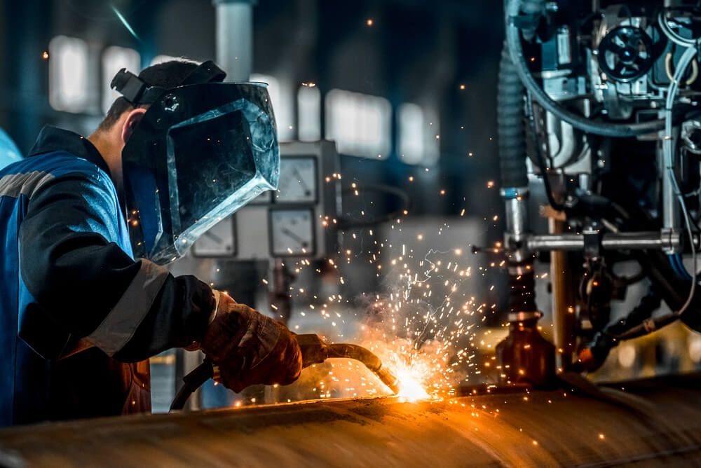 Welder using gas metal arc welding on a large steel cylinder at the Aditri Engineering fabrication shop in Sriperumbudur
